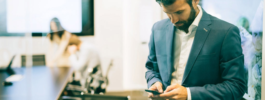 Portrait of businessman using phone in office